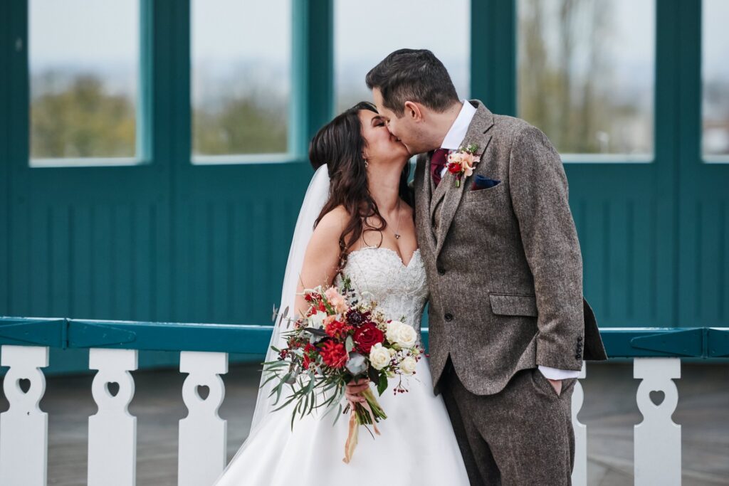 bride and groom kissing in front of the bandstand at The Horniman museum. 