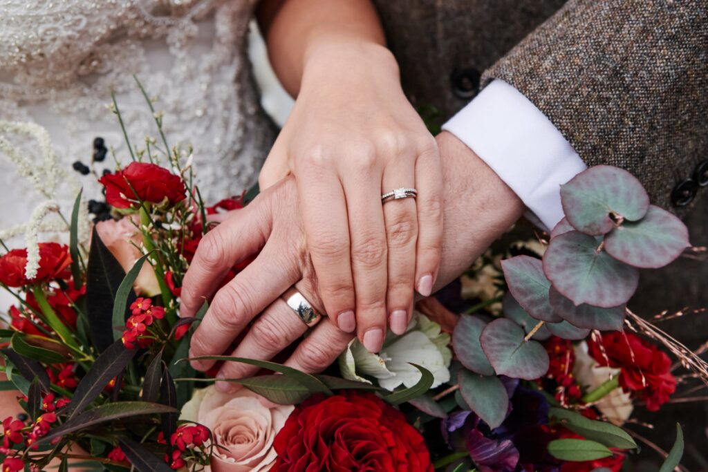 close up of wedding rings on top of flower bouquet during winter wedding 