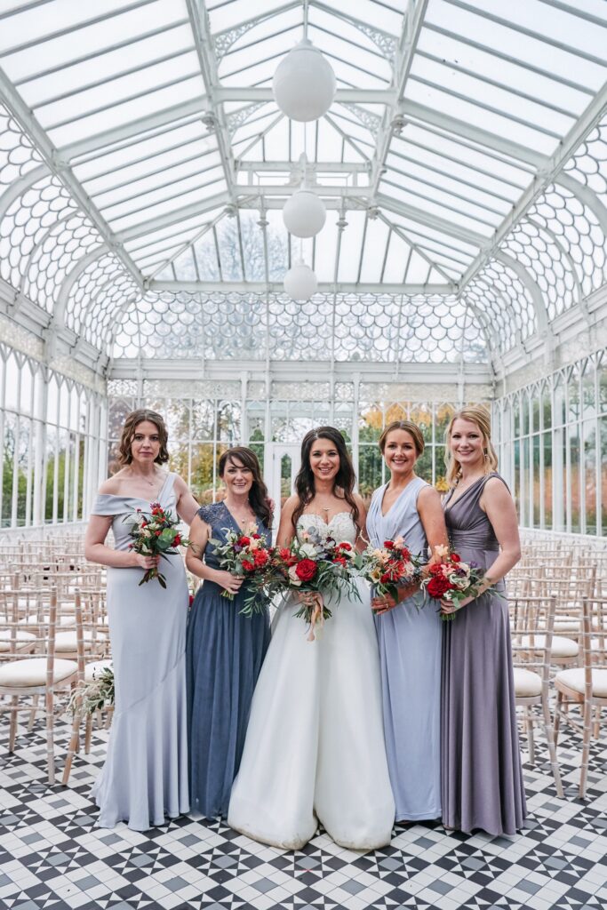 Bride smiling with her bridesmaids in the conservatory at The Horniman Museum
