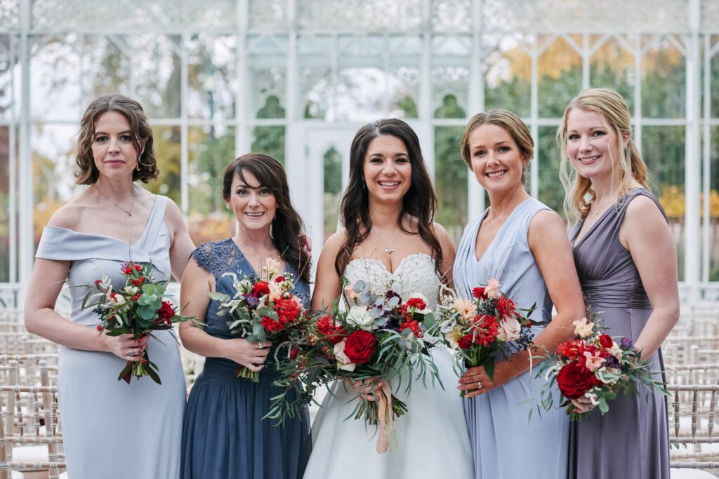 Bride smiling with her bridesmaids in the conservatory during winter wedding