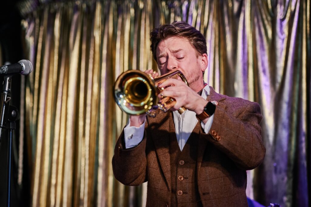 Trumpet player on the stage during winter wedding at Ivy House