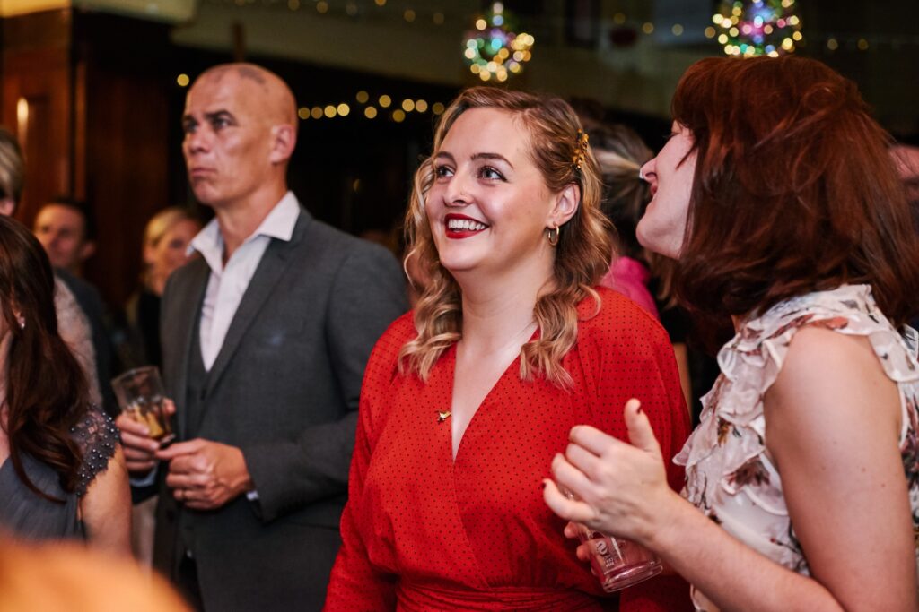 happy wedding guest watching performances at The Ivy House